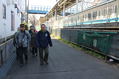 小田急線の横の道路を歩いている写真