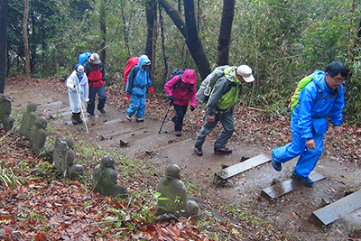 雨が止んだ中で、羅漢像横の登山道を登っている写真