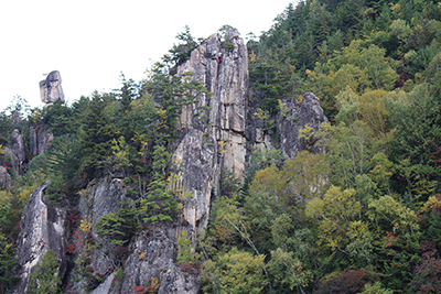 廻目平の岩場と登っているクライマーの写真