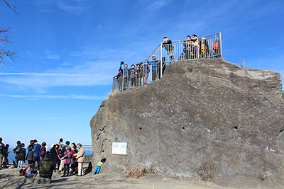 山頂展望台の岩の上に上がっているメンバーと岩の写真