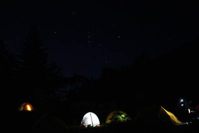 夜の光るテントとオリオン座の写真