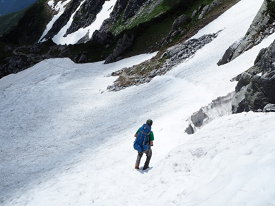 Iさんが撮影した鬼岳の雪渓を下っているAさんの写真