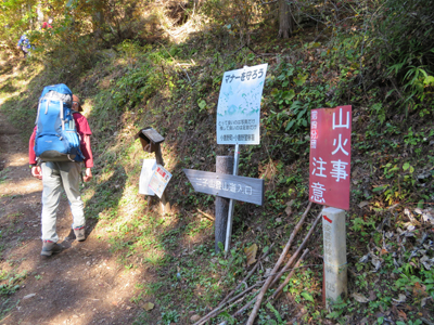 Mさんが撮影した坂本登山口の標識横を歩いている写真