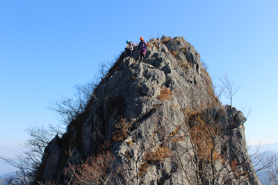 すごい岩峰の上に立っているスーパーウーマン2人の写真