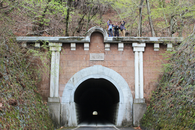 歴史的建造物の笹子隧道の上で手を振るメンバーの写真