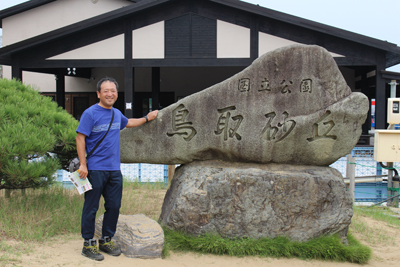 鳥取砂丘の石でできた標識とIさんの写真