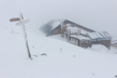 雪に少し埋もれている蓼科山頂ヒュッテの写真