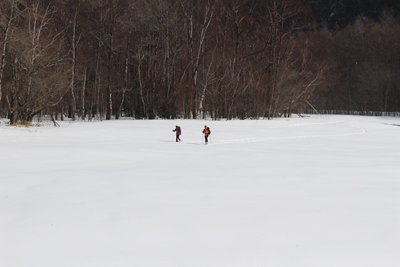 雪原の上をスノーシューで歩くペアの写真
