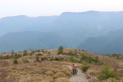 美ヶ原を背に鉢伏山山頂直下を上っている写真