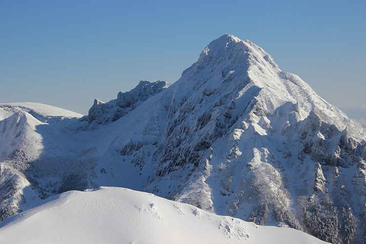 権現岳から見た冬の赤岳の写真