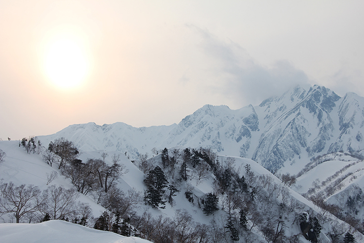 遠見尾根から見た冬の五竜岳と沈んでいく太陽の写真