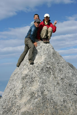 山頂の岩の上に集まった３人の写真