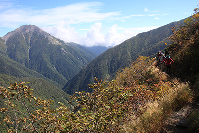 赤石岳を右に見ながら稜線をトラバース気味に歩いている写真