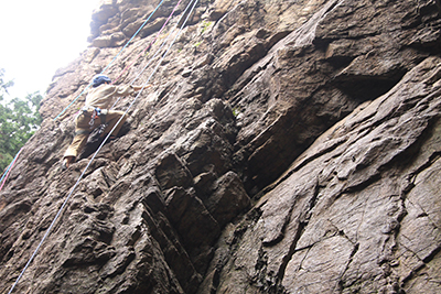 男岩南面のフェースを登るKNさんの写真