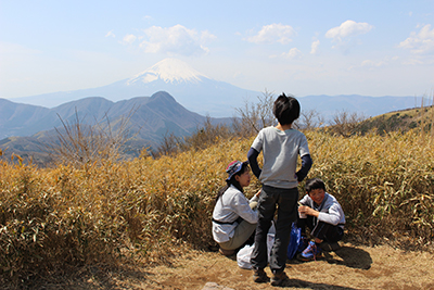 富士山のよく見える山頂で昼食中のKT親子とK君の写真