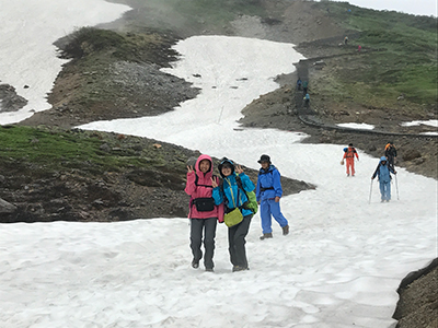 Iさんが撮影した雪渓の上でポーズを取るメンバーの写真