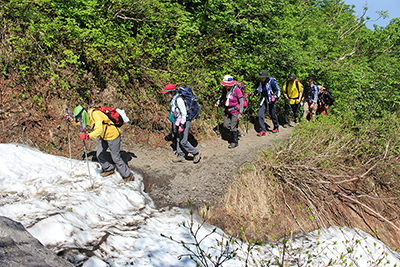 山腹をトラバースし、小さな雪渓を横断している写真
