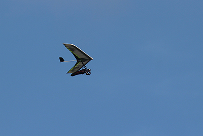 空を舞うハンググライダーの写真