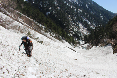 滝谷出合を過ぎ、槍平に向けて残雪の斜面を登っている写真