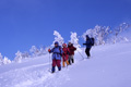 真っ青な空の下冬の根子岳から下山している写真へリンク